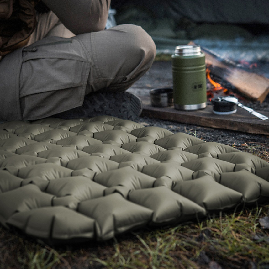 mężczyzna siedzący przy ognisku